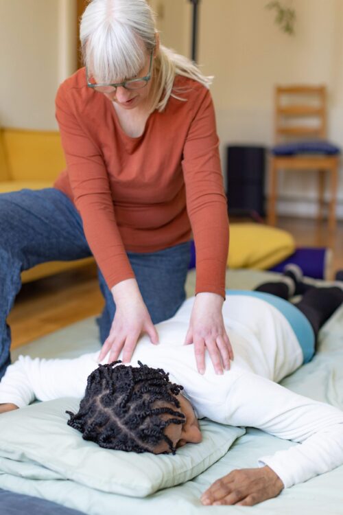 Corrinna Bain, shiatsu practitioner and founder of Rest and Renew, Govanhill, Southside Glasgow with client releasing tension and pain in upper and lower back including using acupressure points