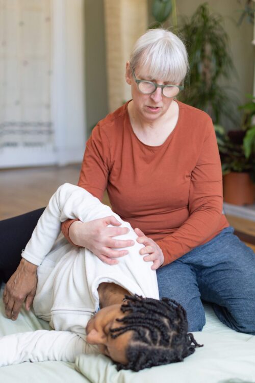 Shiatsu Practitioner Corrinna, doing an arm rotation with a client in order to easy shoulder pain. 